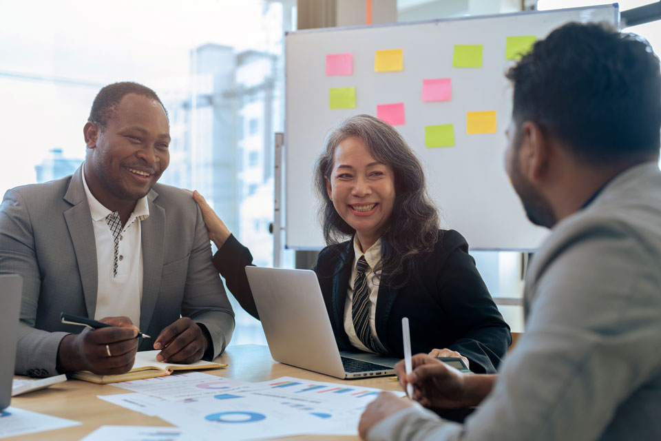 Mature older businesswoman negotiating growth business plan with diverse executive management team.