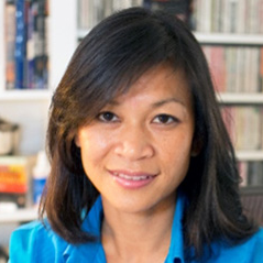 Vietnamese-American Branch Chief, Tram Kim Lam, Ph.D. wearing a blue collared shirt and folding her arms in front of her with a bookshelf in the background