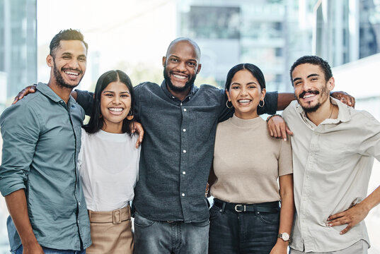 A diverse group of young Hispanic/Latino professionals smiling. 