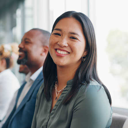 A smiling woman waiting for a job interview.