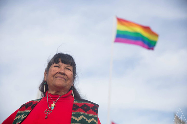 Beverly Little Thunder standing by two-spirit flag at Standing Rock #NoDAPL resistance camp.