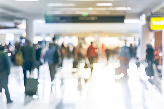 Motion blur of people walking with luggage at airport