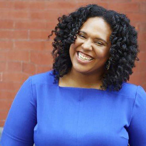 Black woman in blue smiling