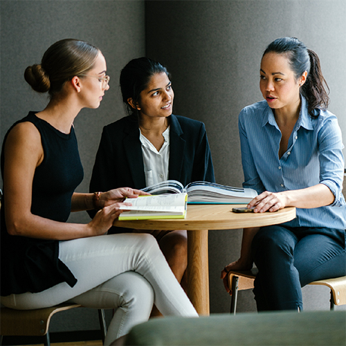 Three women sitting at a table having a conversation