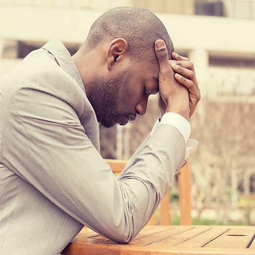 A  black male with head in hands