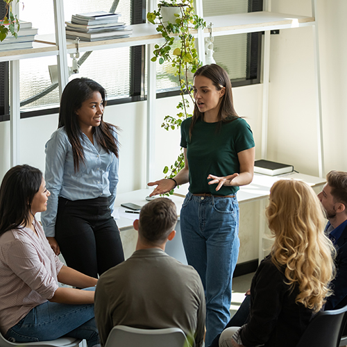 A woman talking to a small group of diverse people