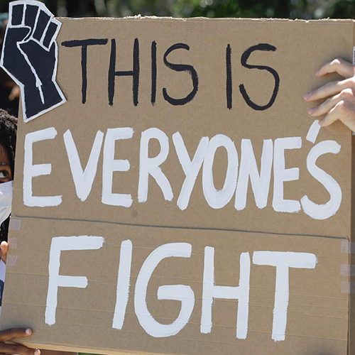 Two Black children holding a protest sign that reads This is everyone’s fight