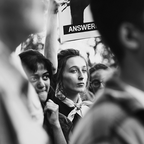 A close-up image of a white woman in a crowd of people