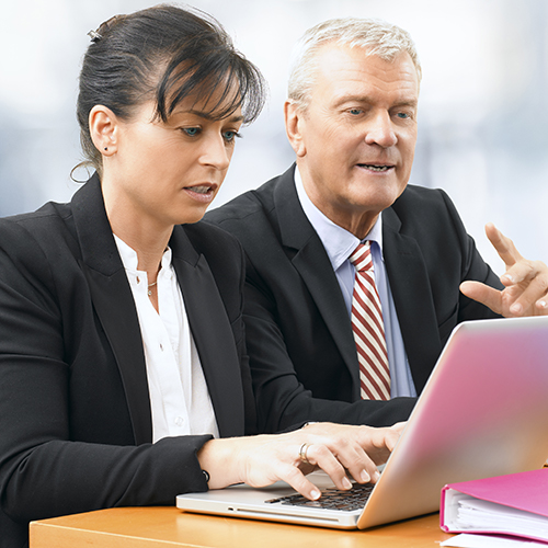 A man and woman looking at a laptop screen