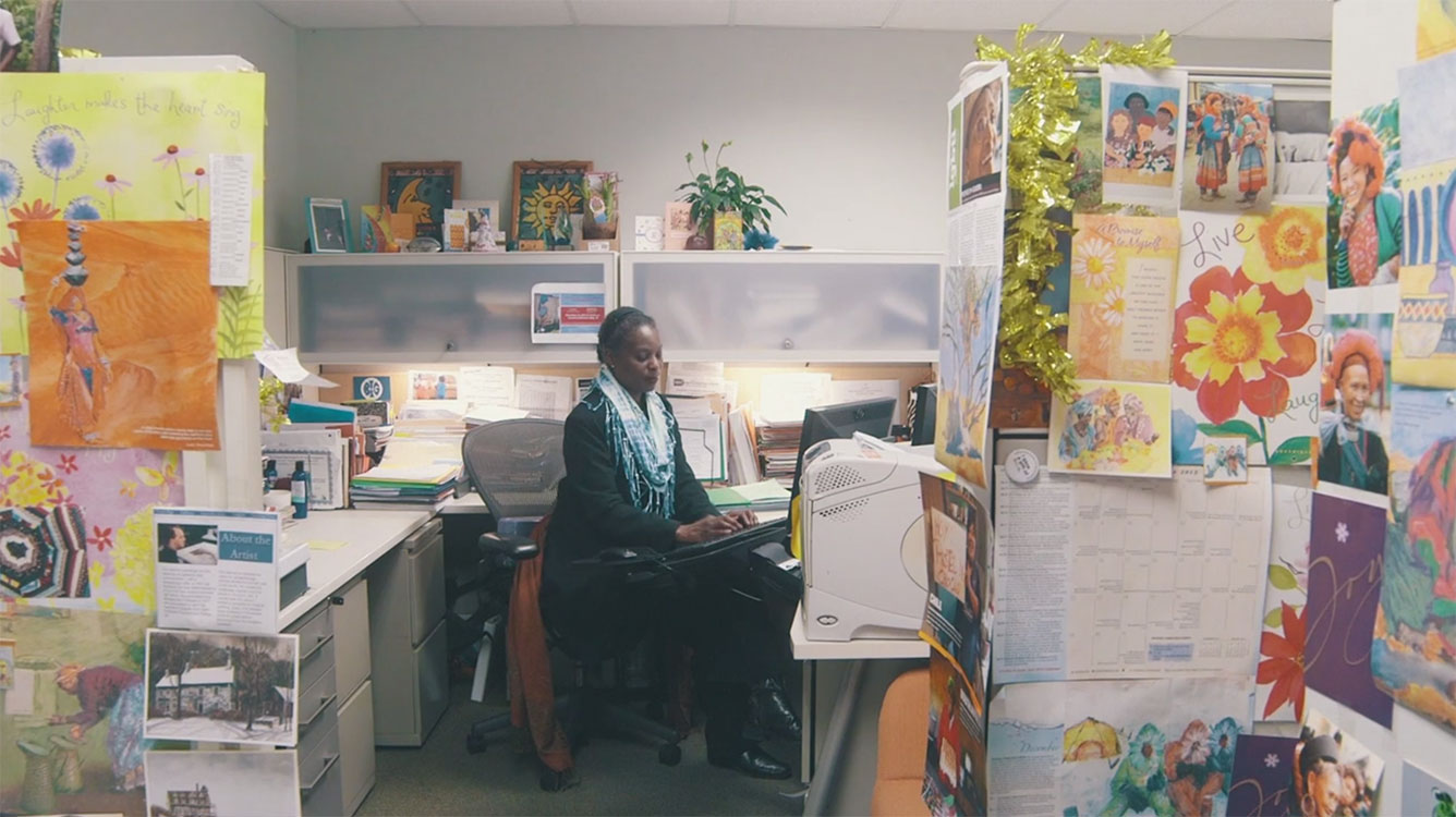 Alfreda Layne working in her colorful and highly decorated cubicle.