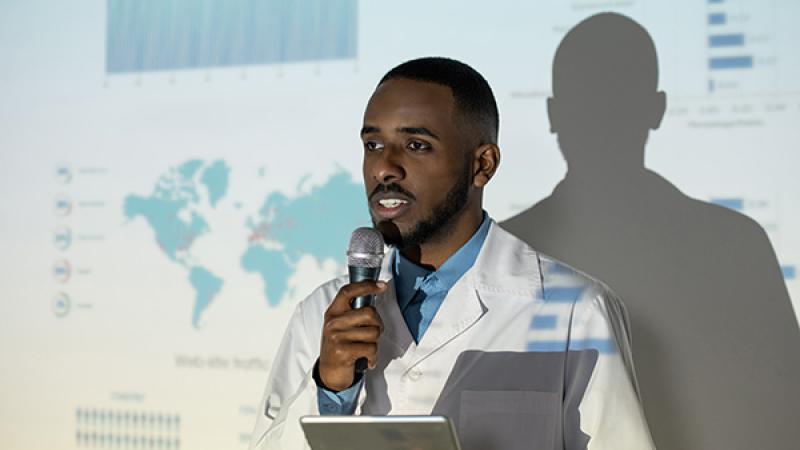 A black medical professional gives a presentation.